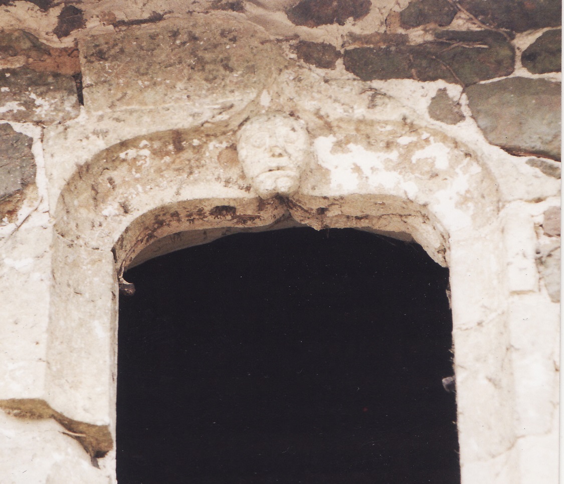 Fenêtre sur cour ornée d'un masque grimaçant.